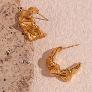 Detailed view of irregular pleated crescent moon earrings in 18K gold plated steel