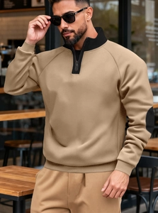 Detail of khaki quarter-zip pullover with black elbow patches and ribbed cuffs