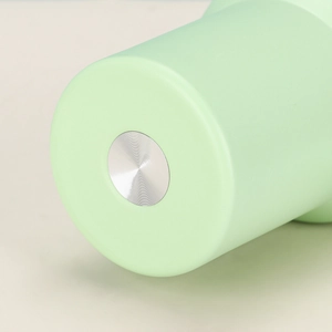 Close-up of the light green insulated tumbler base showing anti-slip metallic circle texture