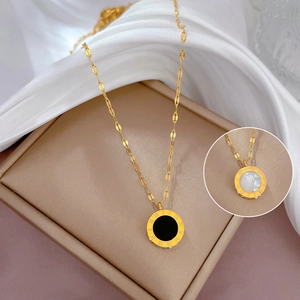 Detailed view of roman numeral necklace pendants in black and white mother of pearl