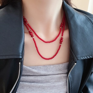 Detailed view of double-layered dark red crystal beaded necklace with gold accents