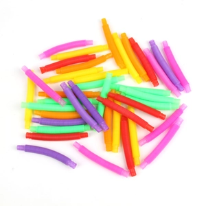 Close-up of colorful plastic pop tubes in various bright shades on a white background