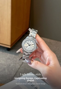Detailed view of silver steel watch with rhinestone bezel and sunburst texture dial