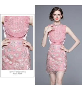 Gros plan sur la robe rose sans manches avec volants et broderies de fleurs à paillettes