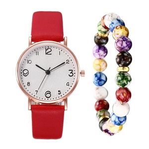 Detail of red leather strap watch and colorful beaded bracelet on a white background