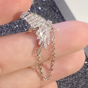 Close-up of silver butterfly wing ear cuff with rhinestones and thin metal chain