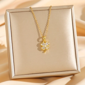 Collier trèfle à quatre feuilles doré avec diamants sur fond élégant en soie brillante