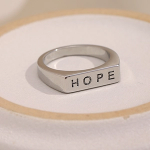 Detailansicht eines silbernen minimalistischen Rings mit gravierter rechteckiger HOPE-Platte