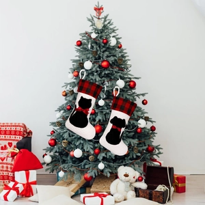 Detail of red and black plaid Christmas stockings with cat and dog silhouettes on a tree