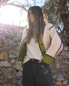 Detail of quilted jacket with green contrast trim and diamond pattern stitching