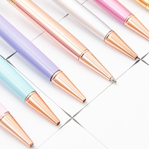Elegant metal ballpoint pens with dried flowers in pastel colors and rose gold trim