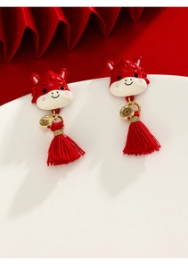 Detailed shot of enamel horse earrings with red cotton tassels and golden coin charms