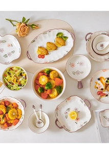 Flat lay of underglaze ceramic bowls and plates featuring pink floral patterns and food