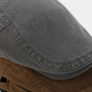 Gros plan sur le tissu texturé vintage des casquettes plates grises et brunes