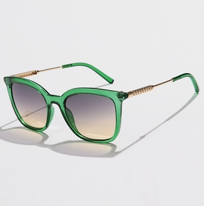Detail of green transparent sunglasses with gold metal temples and gradient purple lenses