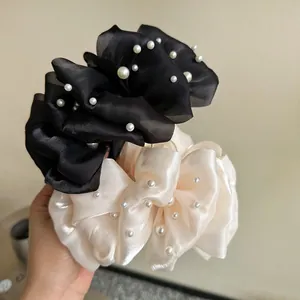Dettaglio di grandi mollette per capelli in rete a bolle con decorazioni di perle fini