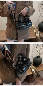 Detail view of glossy black retro saddle bag with dual front pockets and textured strap