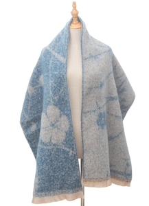 Detail of blue and beige jacquard floral pattern on scarf with short fringe tassels