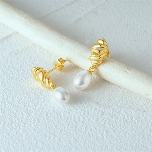 Detail of twisted 18k gold drop earrings with elegant white pear-shaped pearls