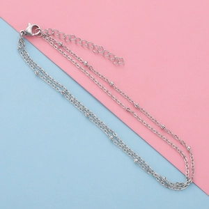 Detail of silver stainless steel beaded chain with lobster clasp on bi-color background