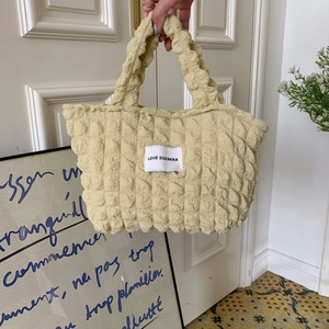 Detail of light yellow bubble texture tote bag with Love Sozakka woven label and zipper