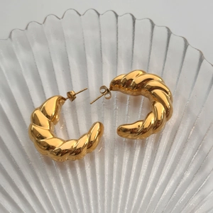 Polished 18k gold plated chunky hollow twist hoop earrings on a shell glass tray
