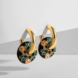 Detailansicht goldener Vintage-Ohrringe mit schwarzer Emaille und Blumenmotiven