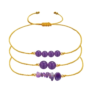 Detail of three handmade braided amethyst bracelets with gold beads and yellow cord