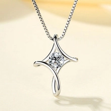 Macro shot of 925 silver cross pendant with center sparkling round cut zircon stone