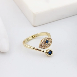 Close-up of gold evil eye snake ring featuring a blue crystal and white rhinestones