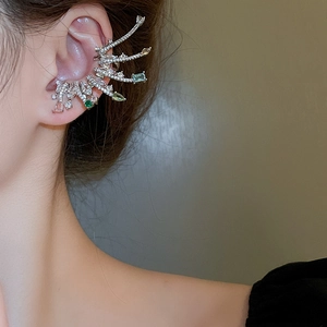 Gros plan d'un ear cuff en zircon coloré scintillant au design d'aile de luxe sur mannequin