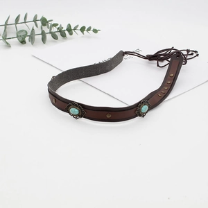 Detail of bohemian brown leather hat band featuring turquoise stones and bronze metal studs