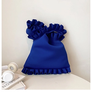 Macro side view of royal blue pleated handbag with layered ruffles and scuba fabric texture