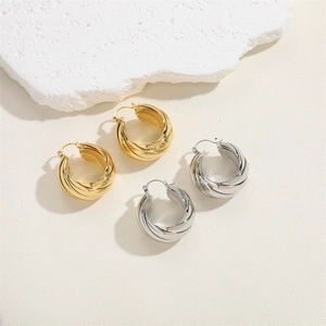 Detailed view of twisted chunky hoop earrings in polished gold and silver metal finishes