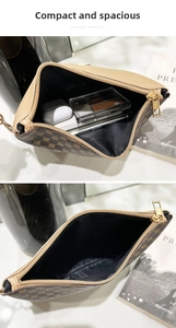 Detail showing the storage capacity of the brown monogram clutch with a golden zipper