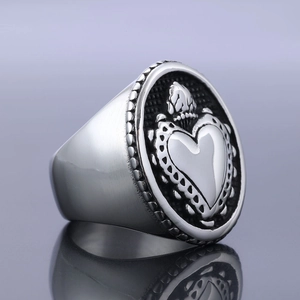 Macro view of vintage stainless steel sacred heart ring with crown relief carving