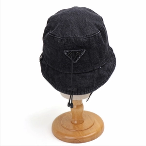 Detail of dark grey washed denim bucket hat with adjustable elastic drawstring and toggle