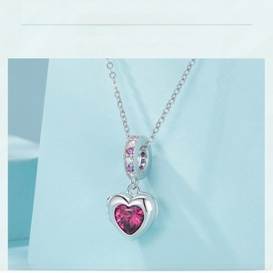 Macro shot of S925 sterling silver heart pendant with pink gemstone and crystal inlay