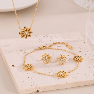 Detail of gold daisy jewelry set with necklace, bracelet, and earrings on display