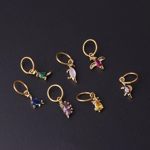 Set of seven golden 18G dinosaur pendants with colorful zircon stones on black background