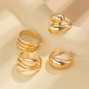 Close-up of a 4-piece set of minimalist gold rings with irregular liquid textures