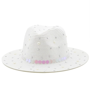 Detail of white straw hat featuring gradient sequins, scattered rhinestones and pearls