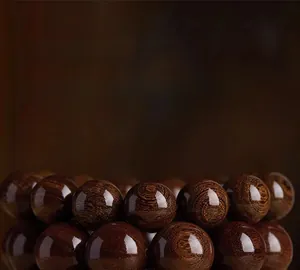 Macro detail of natural sandalwood beads showing clear wood grain and polished oily texture