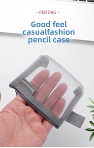 Close-up of gray nylon mesh pen bag with zip closure and fabric label on a desk