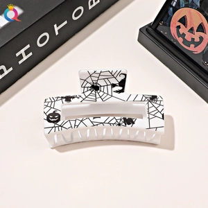 Detail of square Halloween hair claw featuring spider webs and pumpkin silhouettes