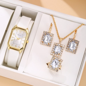 Close-up of elegant gold watch and rhinestone jewelry set in a white gift box
