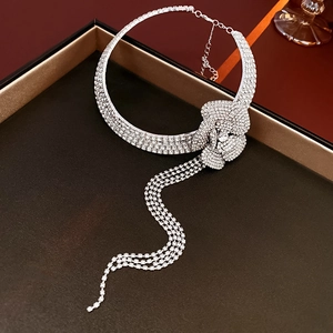 Detailed view of a silver floral tassel necklace with sparkling rhinestones on a gift box