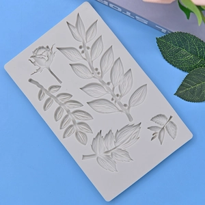 Silicone mold featuring rose and leaf shapes for DIY cake decorating on blue background