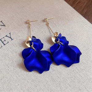 Detail of royal blue petal tassel earrings with gold finish and zircon stones