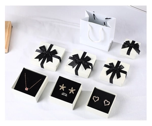 Detail view of elegant orange jewelry boxes and bags with black ribbons and accessories